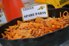 a bowl filled with orange cheetos sitting on top of a table next to other items