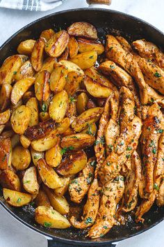 chicken and potatoes in a skillet with parsley on the side, ready to be eaten