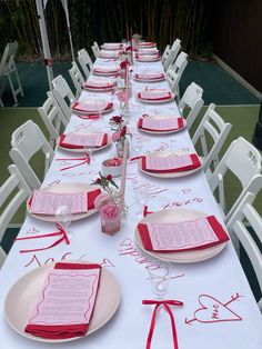 the table is set with pink and red place settings