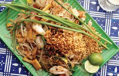 a green plate topped with lots of food on top of a blue and white table cloth