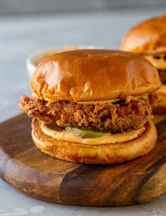 two sandwiches with meat and pickles on a wooden board