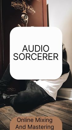 a man sitting on the floor next to a wall with an audio sourcer above it