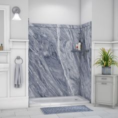 a white bathroom with grey marble tile on the shower wall