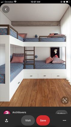 two bunk beds in a room with wooden floors and white walls, one is blue and the other has pink pillows