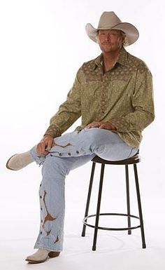 a man sitting on top of a stool wearing a cowboy hat