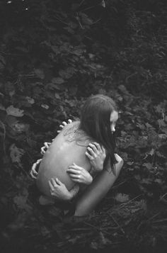 a woman with her arms around another woman's head, in the middle of leaves