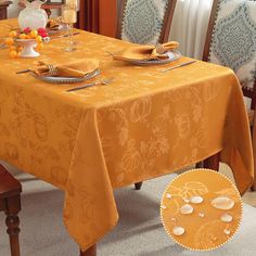 an orange table cloth with white flowers and leaves on it is sitting in front of a dining room chair