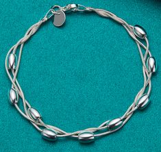 Add a touch of elegance to your wrist with our Triple Strand Silver Chain Bracelet. This bracelet features three strands of high-quality silver chains, each adorned with delicate silver beads, creating a beautiful and unique design that will elevate any outfit. The bracelet is crafted with attention to detail, and the silver beads are evenly spaced along the three strands, creating a symmetrical and balanced look. The bracelet is finished with a sturdy clasp that will keep it securely in place t Elegant Multi-strand Silver Beads Bracelet, Elegant Multi-strand Sterling Silver Bracelets, Elegant Silver Multi-strand Bracelets, Silver Multi-strand Bracelets With Silver Beads, Silver Multi-strand Bracelet As Gift, Silver Multi-strand Sterling Silver Bracelet, Silver Multi-strand Chain Bracelet Gift, Silver Multi-strand Bracelet For Gift, Silver Double Strand Bracelet