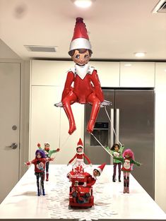 an inflatable elf balloon is being flown over the kitchen counter with several children