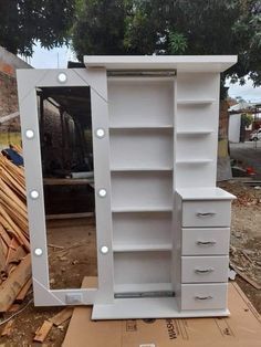 a white dresser with drawers and lights on it