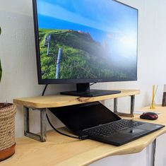 a computer monitor sitting on top of a wooden desk