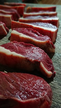 several pieces of meat sitting on top of a cutting board