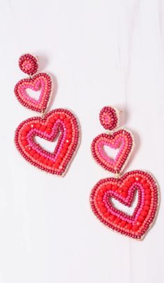 "This double heart earring is charming! It has two open heart drops with shades of red beading. It has a matching beaded post and is felt covered on the back. Dimensions: 3.5\" long" Cheap Red Heart Bead Earrings, Red Dangle Heart Earrings, Red Dangle Earrings For Valentine's Day, Valentine's Day Red Dangle Earrings, Red Double Heart Charm Earrings, Red Heart Charm Earrings With Pendant, Red Heart Charm Earrings For Valentine's Day, Double Heart Earrings For Valentine's Day, Red Heart Charm Earrings