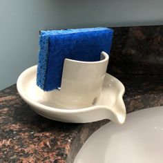 a blue sponge sits on top of a white dish