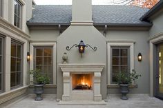 an outdoor fireplace with potted plants in front of it