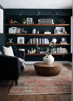 a living room filled with furniture and bookshelves next to a wall mounted book shelf