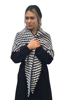 a woman wearing a black and white knitted shawl with hounds pattern on it