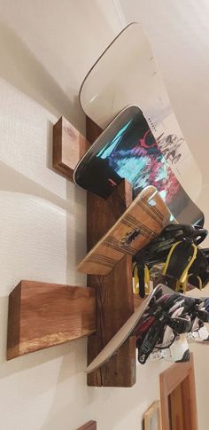 a snowboard mounted to the side of a wall with skis hanging from it