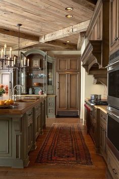 a large kitchen with wood floors and wooden ceilinging, along with an island in the middle