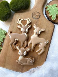 cookies decorated with deer and hearts on a cutting board