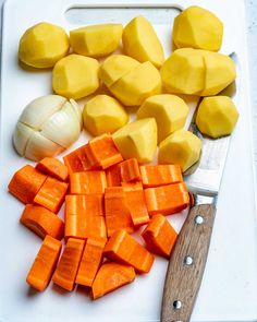 chopped up carrots and onions on a cutting board with a knife next to them