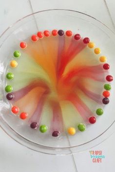 there is a cake decorated with candies in the shape of a circle on top of a glass plate