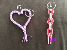 two key chains made to look like hearts with ribbons on them, one is purple and the other is pink