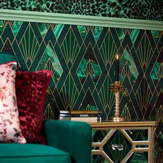 a living room with green and gold wallpaper, a blue chair and a candle