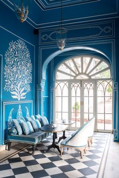 a room with blue and white walls, checkerboard flooring and arched doorways