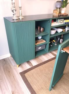 a green cabinet sitting on top of a hard wood floor