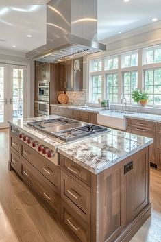 a large kitchen with marble counter tops and wooden cabinets, along with hardwood flooring