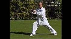 a man in white is practicing his moves on the grass