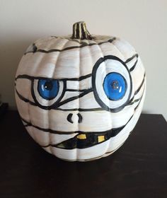 a white pumpkin with blue eyes painted on it