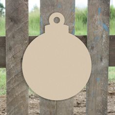 a wooden fence with a round ornament hanging from it's side on top