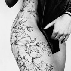 black and white photograph of a woman's thigh with flowers tattooed on the side