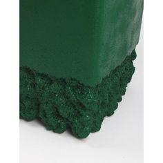 a close up of a green object on a white surface