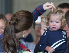 the young child is being held up by two women as they look at each other