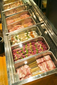 an assortment of meats and vegetables on display in a buffet