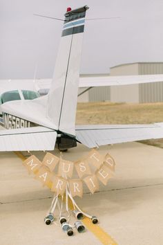 a small airplane parked on top of an airport tarmac next to a bunting banner