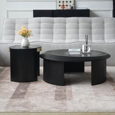 a living room with two coffee tables and a couch in the background on carpeted flooring