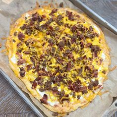 a pizza sitting on top of a pan covered in cheese and toppings with meat