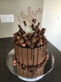 there is a chocolate cake that has been decorated with icing and chocolate candies