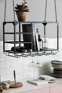 a shelf with some books and plates on top of it, hanging from the ceiling