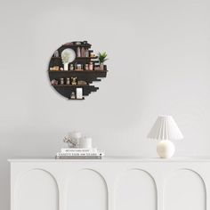 a room with a white cabinet and a clock on the wall next to a lamp