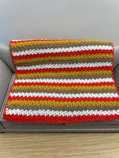 a crocheted blanket sitting on top of a couch