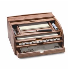 a wooden desk organizer with many items in it's drawer and pen holder on top