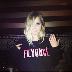 a woman with blonde hair wearing a black shirt that says foynce on it