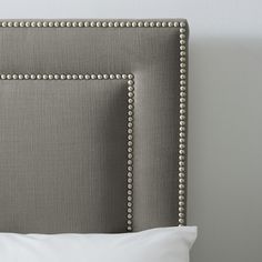 an upholstered headboard with studded trim