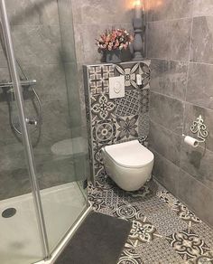 a bathroom with grey and white tiles on the walls, flooring and shower stall