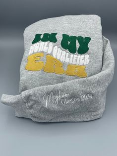 This sweatshirt is the must have for your World Qualifier. What could be more special than a super soft hoodie with custom embroidery? It is a keepsake in addition to what will be their new favorite hoodie. Celebrate in style! The colors are the Irish Flag of course, embroidered by our friends at Irish Stitch Embroidery. You have your choice of a grey or black hoodie and could have a classic hoodie OR we can add some bedazzle with a sparkle rope. Our processing time is 5 days, please take note. Green Hooded Sweatshirt With Custom Embroidery, Gray Hoodie Sweatshirt With Embroidered Logo, Gray Embroidered Logo Hoodie Sweatshirt, Gray Long Sleeve Hoodie With Embroidered Logo, Crew Hoodie With Letter Embroidery For Winter, Fleece Hoodie Sweatshirt With Letter Embroidery, Winter Crew Hoodie With Letter Embroidery, Varsity Long Sleeve Hoodie With Embroidered Graphics, Cotton Crew Hoodie With Custom Embroidery